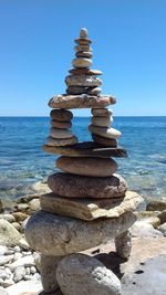 Stack of stones on beach against clear sky