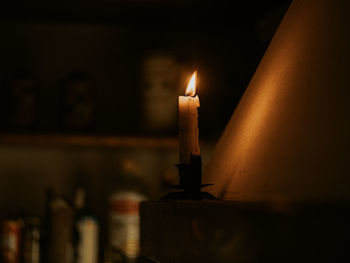Close-up of illuminated candles on table in darkroom
