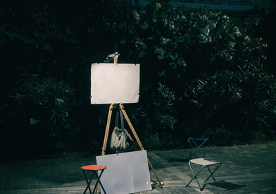 Empty chair and table against trees in yard