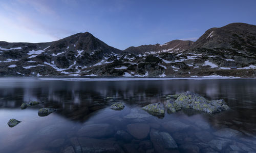 Scenic view of lake and snowcapped mountains against sky