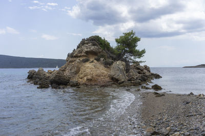 Rock formation on beach against sky