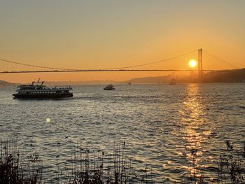 Scenic view of bridge over sea against sky during sunset