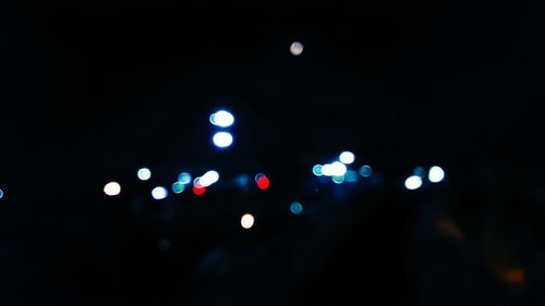 Defocused lights against sky at night