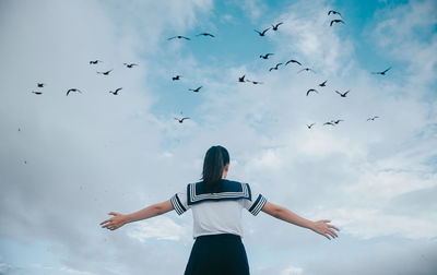 Rear view of woman flying against sky