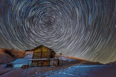 Long exposure image of star trail over landscape at night