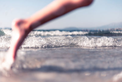 Close-up of hand by sea