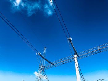 Low angle view of power lines against blue sky