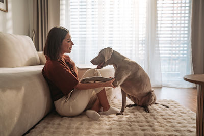 Side view of woman sitting on sofa at home
