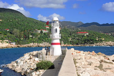 Lighthouse by sea against sky