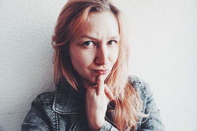 Portrait of young woman against white background