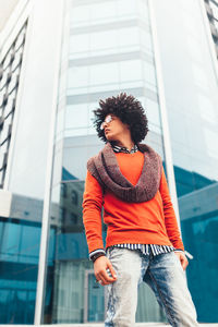 Low angle view of fashionable young man standing against modern office building