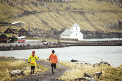 Friends jogging at along rocky coastline