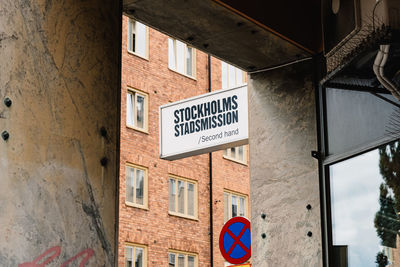 Low angle view of road sign against building