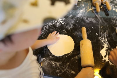 High angle of woman rolling dough on rock