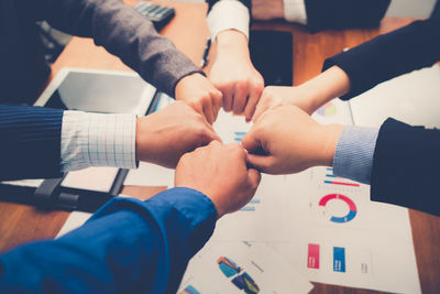 High angle view of colleagues bumping fist over desk