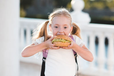 Cute girl holding hamburger