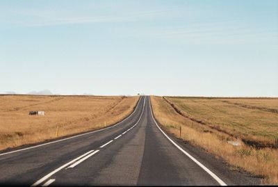 Road passing through landscape against sky