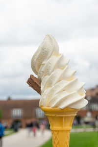 Close-up of ice cream cone against sky