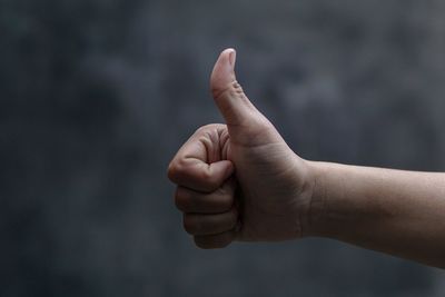 Cropped image of hand gesturing thumb up