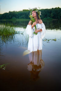 Full length of young woman standing in lake