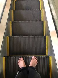 Low section of person on escalator