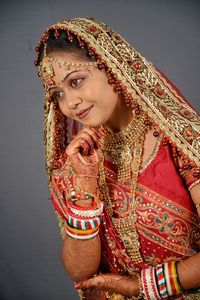 Smiling beautiful young bride standing against wall