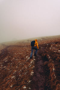 Man skiing on land against sky during winter