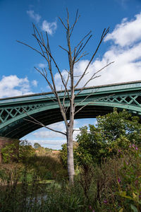 Low angle view of bridge against cloudy sky