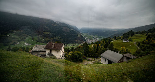 Scenic view of house and mountains against sky