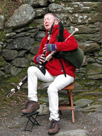 Full length of man sitting outdoors