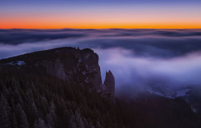 Scenic view of mountain against cloudy sky during sunset