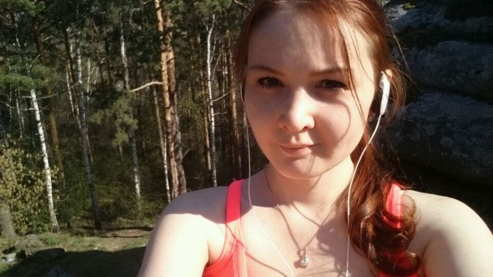 PORTRAIT OF YOUNG WOMAN STANDING IN FOREST