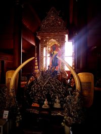 Statue in illuminated temple outside building