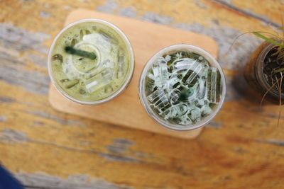 High angle view of matcha tea in disposable cups on table