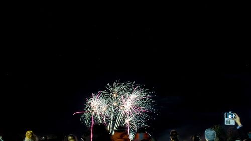 Low angle view of firework display at night