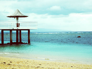 Lifeguard hut on beach against sky