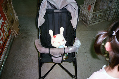 High angle view of teddy bear in baby stroller at home