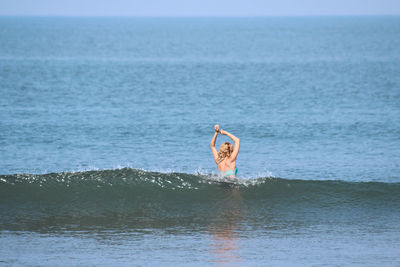 Man surfing in sea against sky