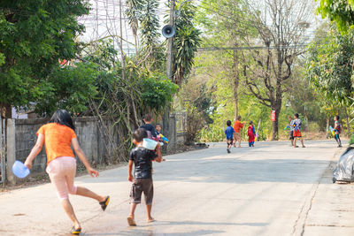 Rear view of people walking on street in city