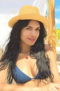 Portrait of sensuous young woman wearing hat at beach