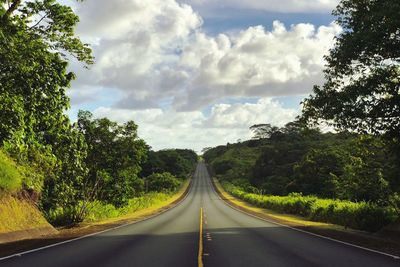 Road amidst trees against sky