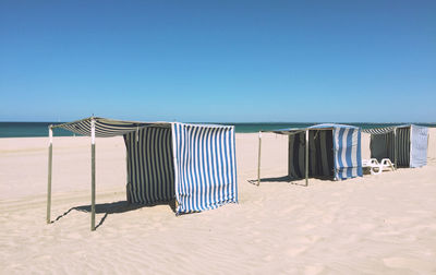 Tents at beach against clear sky