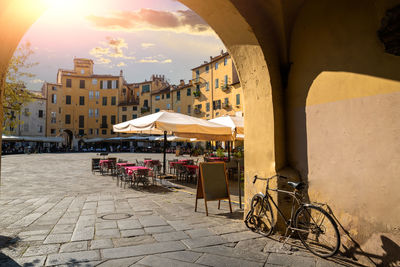 Lucca, tuscany, italy. view  of the entrances to the amphitheater square. a bike parked on the wall.