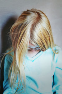 Girl with blond hair against wall