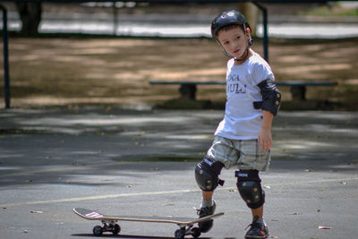 Full length of boy skateboarding on road 