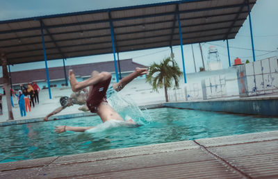 People jumping in swimming pool