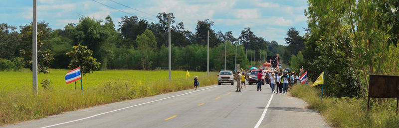 Panoramic view of road amidst trees against sky