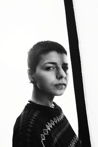 Portrait of young woman looking away against wall