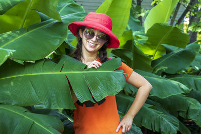 Portrait of smiling woman by plants outdoors