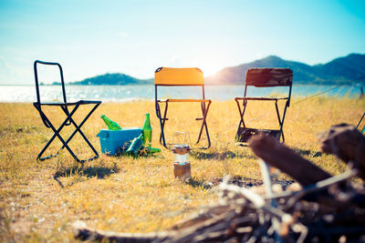 Empty chairs on field during sunny day